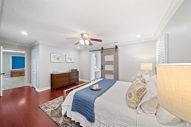 bedroom featuring connected bathroom, a barn door, ceiling fan, and dark hardwood / wood-style floors