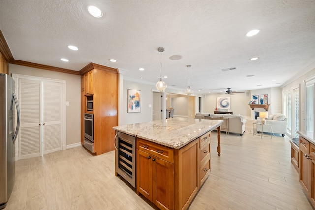 kitchen with pendant lighting, a center island, light hardwood / wood-style flooring, stainless steel appliances, and beverage cooler