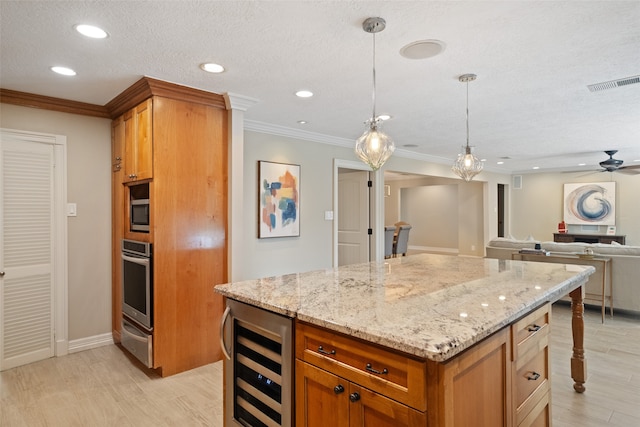 kitchen featuring ceiling fan, stainless steel oven, beverage cooler, pendant lighting, and a kitchen island