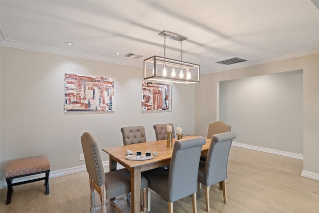 dining area with a textured ceiling, light hardwood / wood-style floors, and crown molding