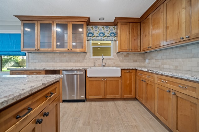 kitchen featuring dishwasher, crown molding, sink, decorative backsplash, and light hardwood / wood-style floors