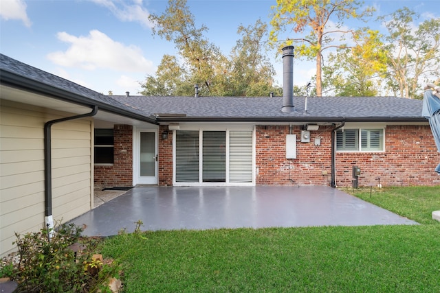 back of house with a lawn and a patio