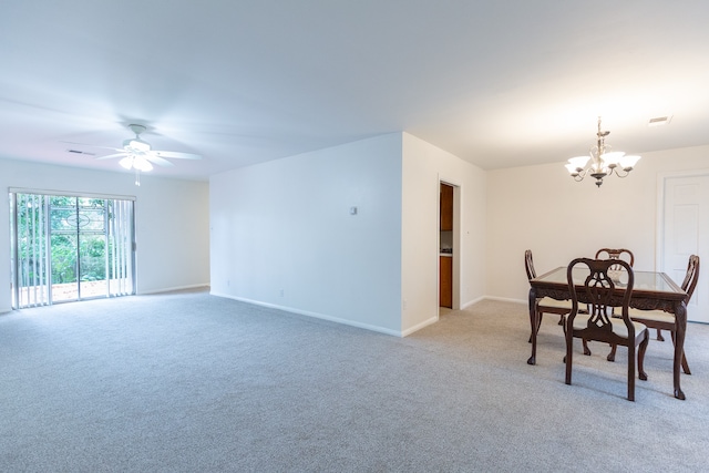 carpeted dining space featuring ceiling fan with notable chandelier