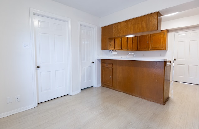 kitchen with light hardwood / wood-style floors and kitchen peninsula