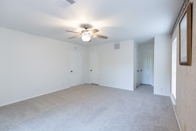 carpeted spare room with ceiling fan