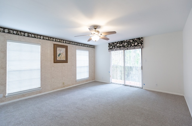 carpeted spare room featuring ceiling fan and a healthy amount of sunlight