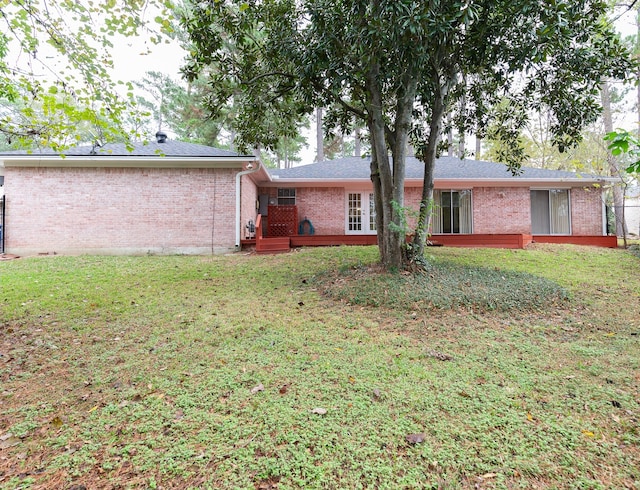 rear view of house featuring a deck and a yard