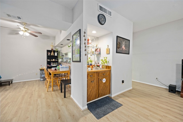 interior space with ceiling fan, light hardwood / wood-style flooring, and sink