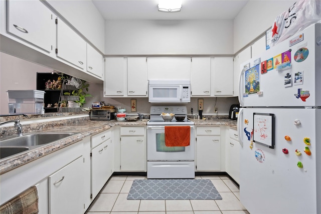 kitchen with light tile patterned floors, white appliances, and white cabinetry