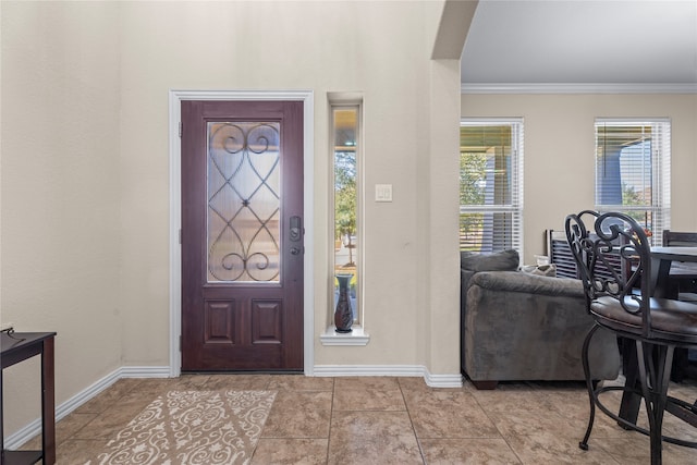 entrance foyer featuring ornamental molding and light tile patterned floors