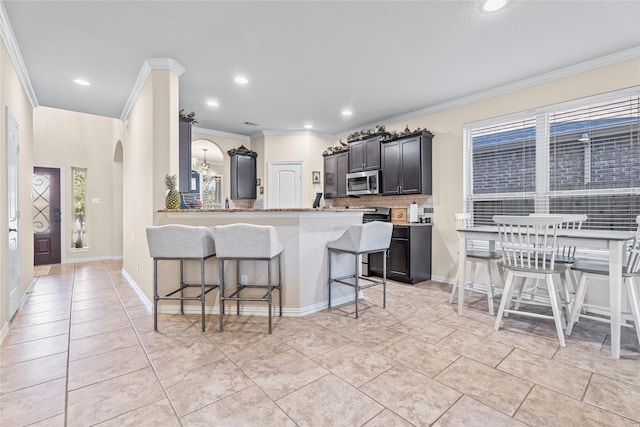 kitchen featuring a kitchen breakfast bar, ornamental molding, and backsplash