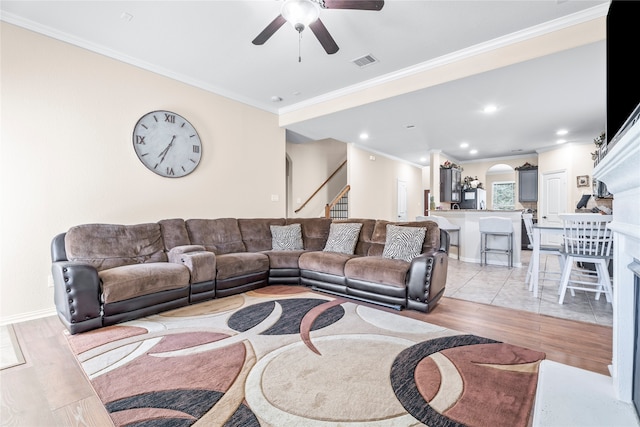 living room with ceiling fan, light hardwood / wood-style flooring, and ornamental molding