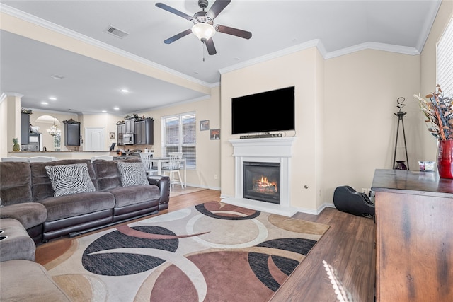 living room with crown molding, ceiling fan, and light hardwood / wood-style floors