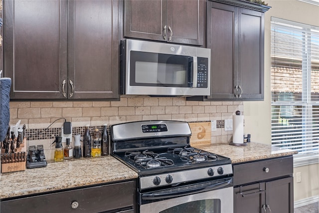 kitchen with decorative backsplash, plenty of natural light, stainless steel appliances, and dark brown cabinets