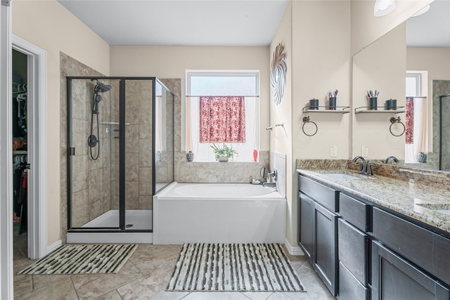 bathroom featuring tile patterned floors, vanity, and shower with separate bathtub