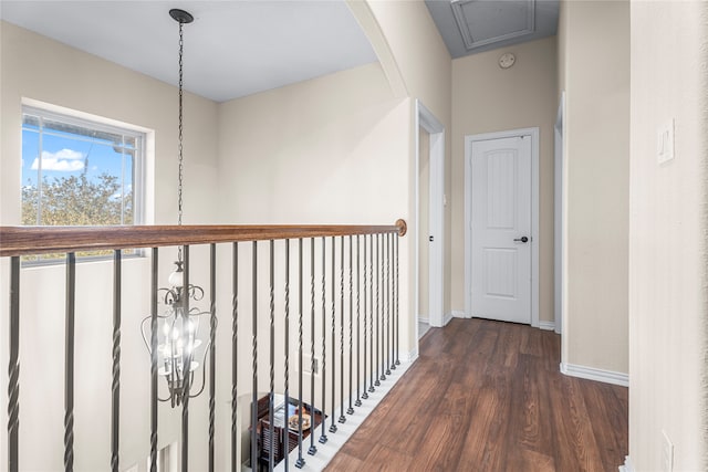 hall with a chandelier and dark wood-type flooring