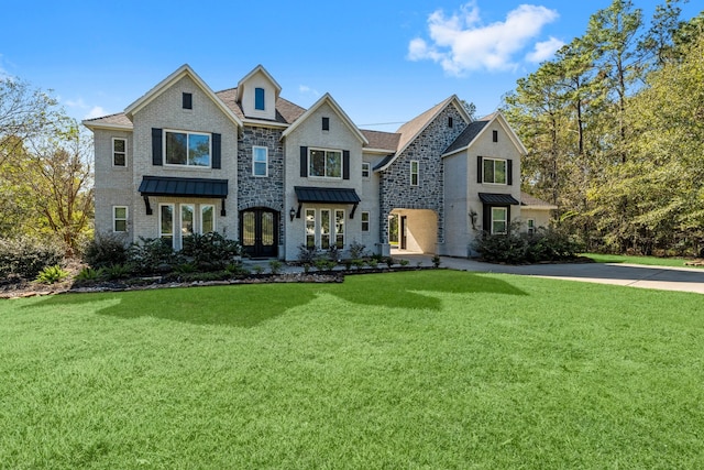 view of front of house featuring a standing seam roof, metal roof, and a front lawn