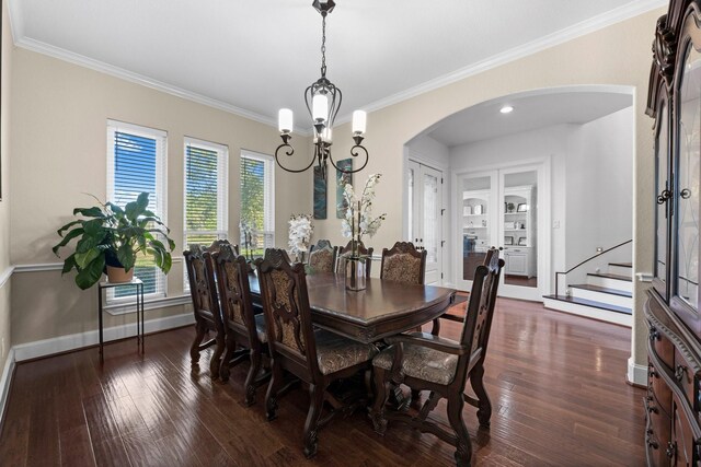 dining area with crown molding, built in features, a chandelier, and dark hardwood / wood-style flooring