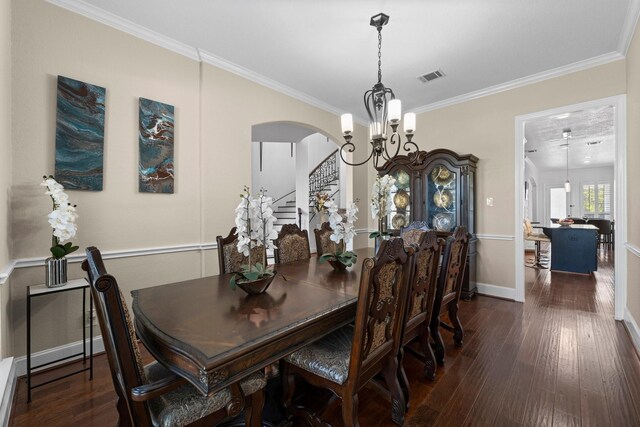 dining space featuring dark hardwood / wood-style flooring, crown molding, and an inviting chandelier