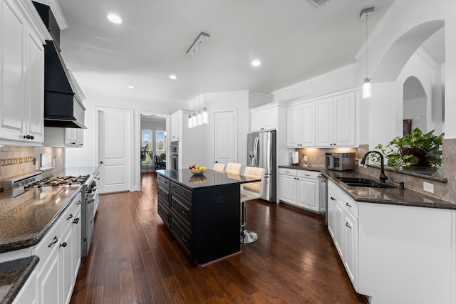 kitchen with pendant lighting, a center island, appliances with stainless steel finishes, and sink