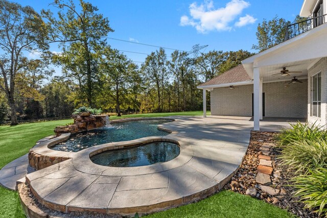 view of swimming pool featuring ceiling fan, an in ground hot tub, a lawn, and a patio