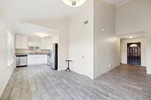 kitchen featuring white cabinetry, sink, crown molding, light hardwood / wood-style floors, and appliances with stainless steel finishes