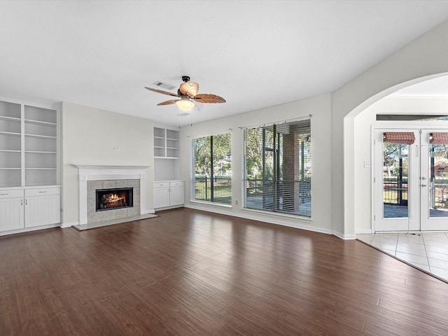 8311 Vaulted Pine Dr, Humble, TX 77346 - unfurnished living room featuring wood finished floors, a ceiling fan, built in shelves, and plenty of natural light