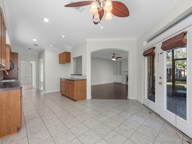 8311 Vaulted Pine Dr, Humble, TX 77346 - kitchen with ceiling fan, brown cabinets, light tile patterned floors, a sink, and recessed lighting