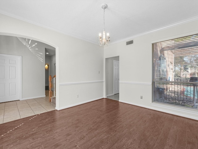 8311 Vaulted Pine Dr, Humble, TX 77346 - empty room with a chandelier, arched walkways, crown molding, wood finished floors, and baseboards