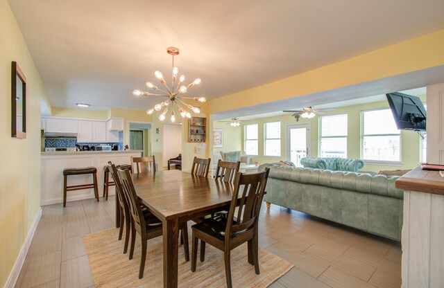 tiled dining space featuring ceiling fan with notable chandelier