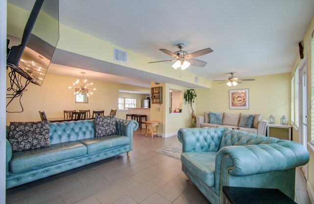 living room featuring ceiling fan with notable chandelier