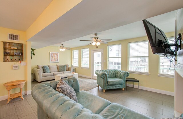 living room with ceiling fan, light tile patterned flooring, and vaulted ceiling