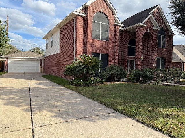 view of front property featuring a garage, a front lawn, and an outdoor structure