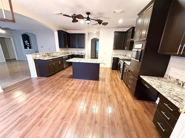 kitchen featuring a center island, sink, appliances with stainless steel finishes, light hardwood / wood-style floors, and kitchen peninsula