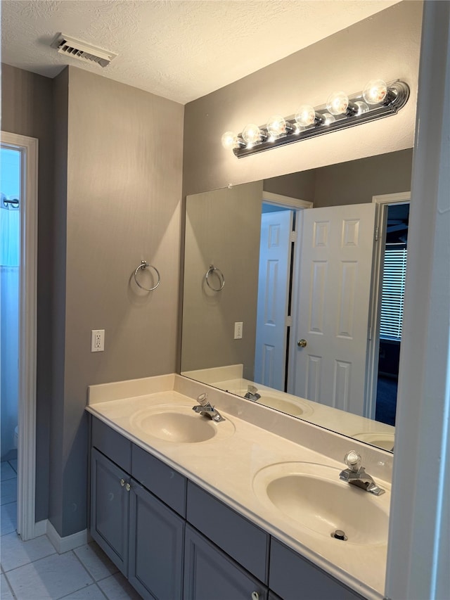 bathroom featuring tile patterned floors, vanity, and a textured ceiling