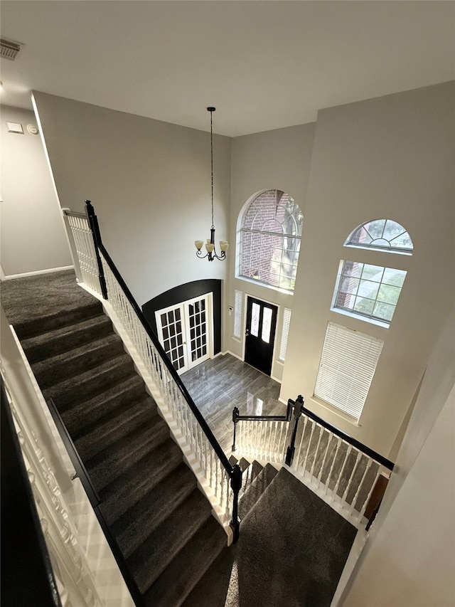 foyer featuring wood-type flooring, a high ceiling, and a notable chandelier