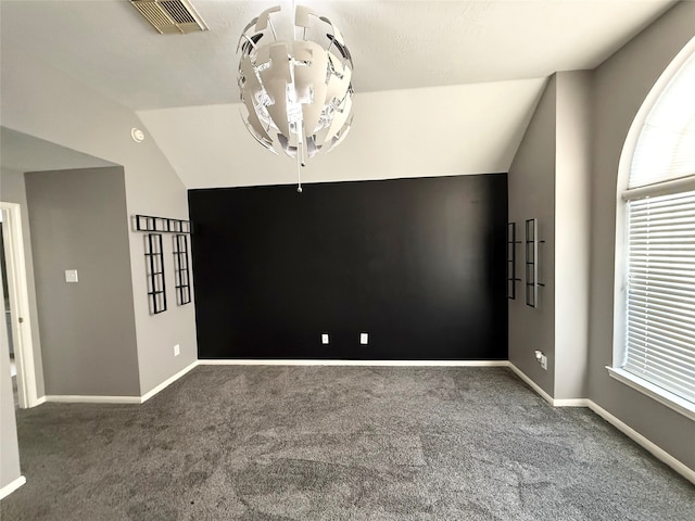 carpeted spare room with vaulted ceiling