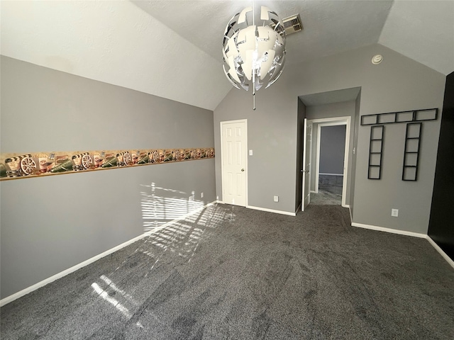 carpeted empty room with vaulted ceiling