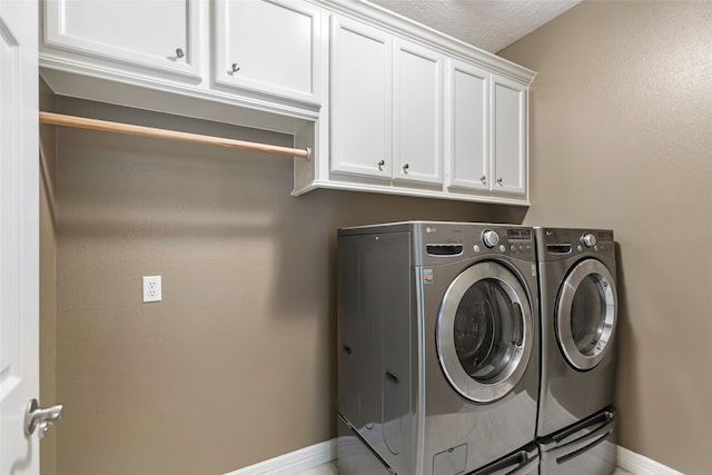 laundry room with cabinets, a textured ceiling, and independent washer and dryer