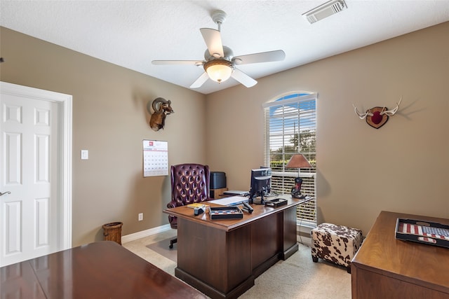 office space featuring a textured ceiling, light colored carpet, and ceiling fan