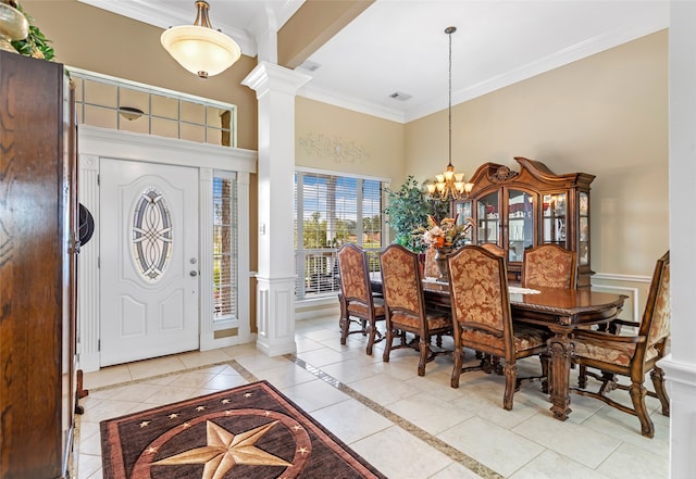 tiled entrance foyer featuring a high ceiling, an inviting chandelier, ornate columns, and crown molding