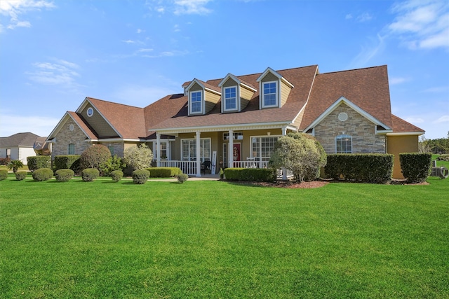 cape cod home with a porch and a front lawn