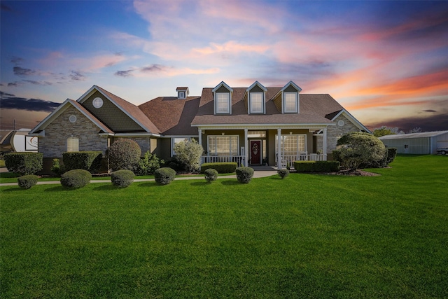 cape cod home featuring a yard and a porch