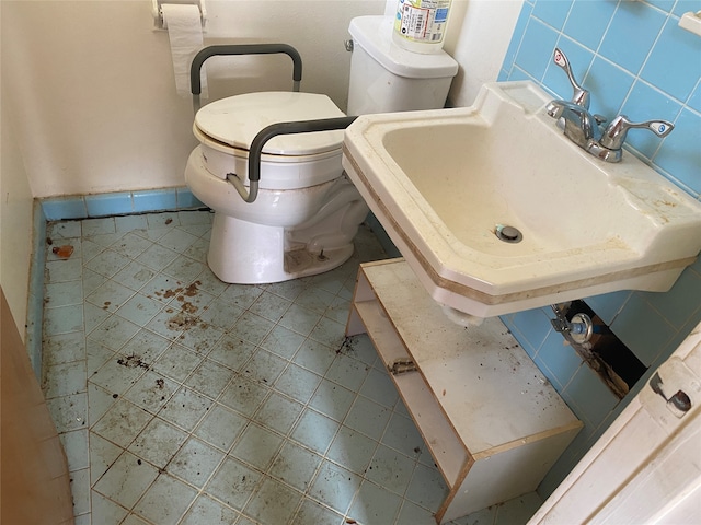 bathroom with sink, backsplash, tile patterned floors, toilet, and tile walls