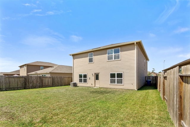 rear view of property featuring cooling unit and a lawn