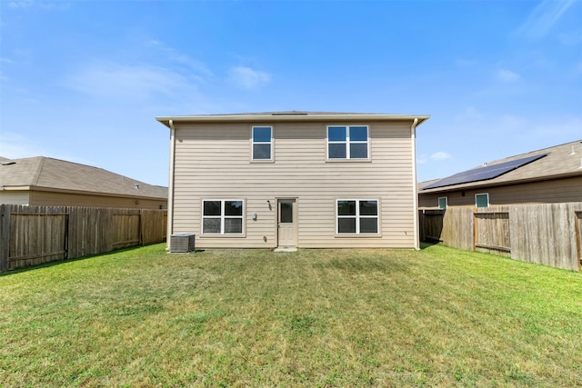 rear view of house featuring a yard and central AC unit