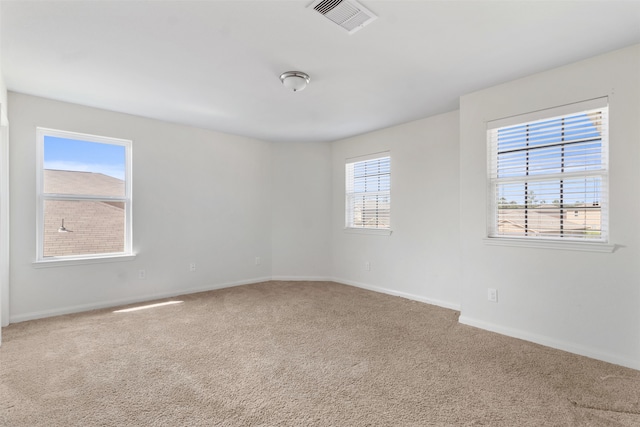 carpeted spare room featuring plenty of natural light