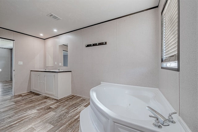 bathroom featuring hardwood / wood-style floors, vanity, and a washtub