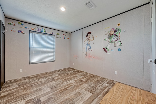 empty room featuring wood-type flooring and a textured ceiling