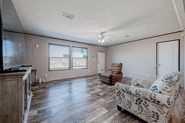 sitting room featuring hardwood / wood-style flooring, ceiling fan, and a textured ceiling